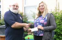 Lion President Brian presenting 97 cheque to Yazmine Hoyle